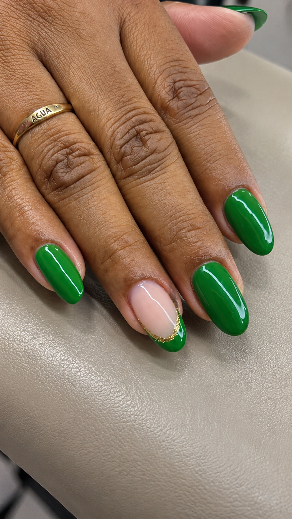 Unhas verdes com anel dourado