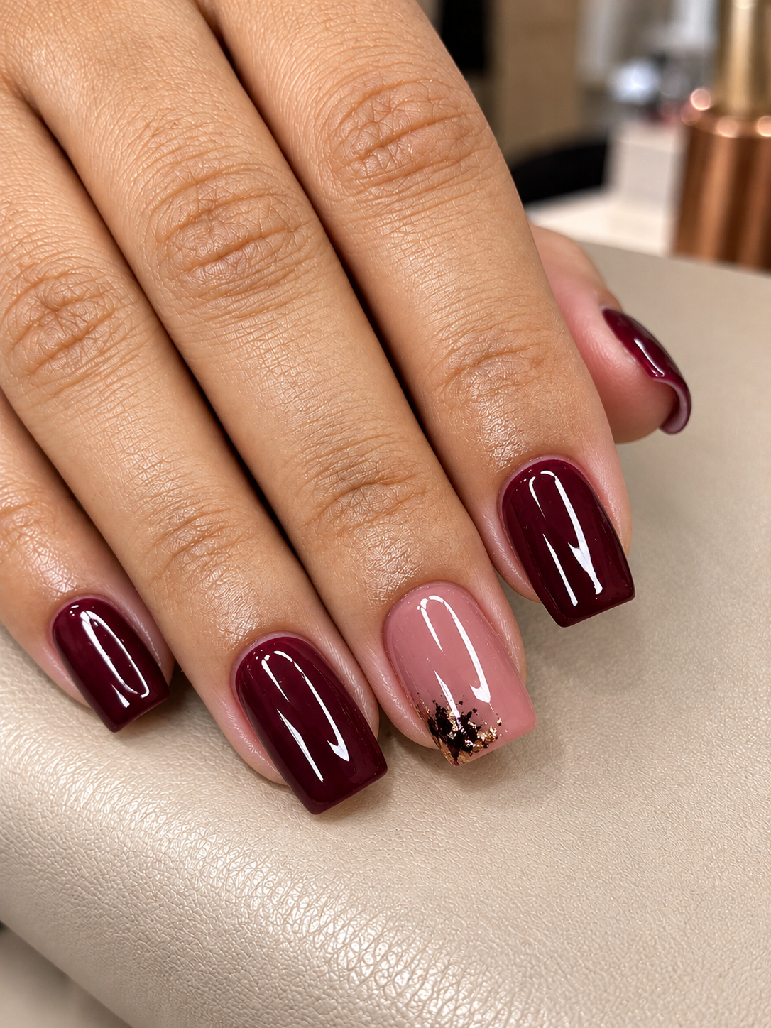 Manicure vinho com detalhe dourado